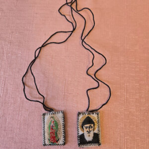 Embroidered fabric scapular. The front features a  image of Saint Charbel, and the back features Our Lady of Guadalupe. Scapular badge measures 1.00 inches wide, 1.15 inches high. Scapular wire length: panel to panel: 14.5 inches. Escapulario de tela bordado  En la parte delantera muestra imagen de San Charbel,  en la parte de atrás la Virgen de Guadalupe. Medidas de la insignia escapular 1.00 pulgadas ancho  de la insignia escapular, 1.15 pulgadas alto Longitud del cable escapular: panel a panel 14.5 pulgadas.