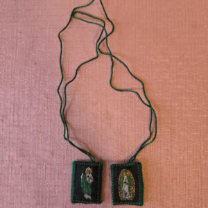 Green embroidered fabric scapular. The front features a half-length image of Saint Jude, and the back features Our Lady of Guadalupe. Scapular badge measures 1.00 inches wide, 1.15 inches high. Scapular wire length: panel to panel: 14.5 inches. Escapulario de tela color verde bordado  En la parte delantera muestra imagen de San Judas,  en la parte de atrás la Virgen de Guadalupe. Medidas de la insignia escapular 1.00 pulgadas ancho  de la insignia escapular, 1.15 pulgadas alto Longitud del cable escapular: panel a panel 14.5 pulgadas.