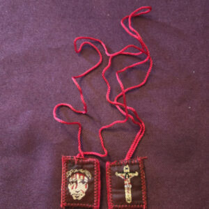 Red fabric scapular embroidered on the front shows the image of the Precious Blood, and the back shows the image of Jesus crucified full body on a thin cord. Scapular badge measures 1 inch wide, 1.15 inches high. Scapular cord length: panel to panel: 17 inches. Escapulario de tela color Rojo  bordado  En la parte delantera muestra imagen Preciosa sangre,  en la parte de atrás muestra imagen Jesús crucificado cuerpo completo cordón delgado. Medidas de la insignia escapular 1 pulgadas ancho  de la insignia escapular, 1.15 pulgadas alto Longitud del cable escapular: panel a panel 17 pulgadas